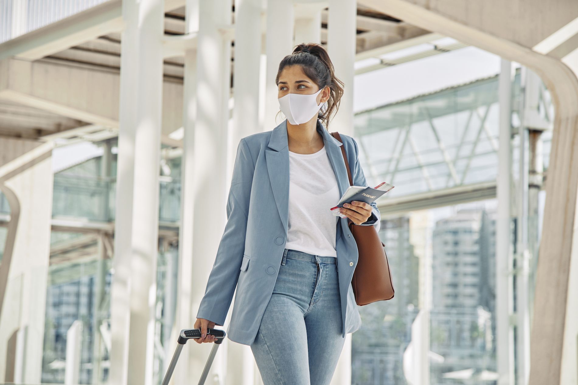 woman-with-luggage-and-medical-mask-at-the-airport-during-pandemic.jpg